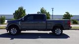 A 2017 Ford F-350 SD in gray with a crew cab and a long bed displaying chrome accents and alloy wheels positioned side view