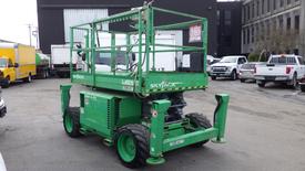 A 2015 Skyjack SJ6826RT rough terrain scissor lift in green with a platform and four large wheels designed for outdoor use