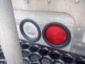 Close-up of two vehicle lights on a Morgan Olson Workhorse W42, one clear lens and one red lens, set in a textured metallic surface
