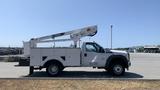 A white 2011 Ford F-450 Super Duty truck equipped with a bucket lift on the rear and utility storage compartments on the sides