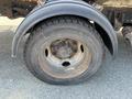 A close-up of a black tire mounted on a metal rim of a 2010 Freightliner MT45 Garbage Truck showing wear and dirt on the tire surface