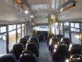 Interior view of a 2016 Chevrolet Express showing rows of seats facing forward and the driver's area at the front