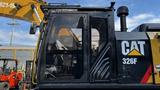 A 2018 Cat 326F Track excavator with a black and yellow color scheme featuring a transparent cabin and large boom arm attached to the side