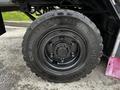 A close-up of a large, rugged tire from a 2007 Tennant Sentinel featuring deep treads and a black rim with visible bolt details