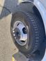 A close-up of a tire from a 2018 Chevrolet Express showing detailed tread patterns and metal wheel rim with lug nuts