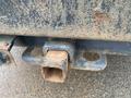 A close-up of a rusted tow hitch attached to the back of a 2009 Ford F-450 SD with visible wear and dirt on the surface