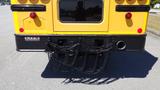 Rear view of a yellow 2014 International 3000 school bus featuring a chain-style bumper guard and red tail lights