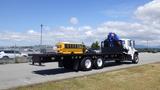 A 2017 Freightliner M2 106 truck with a flatbed and mounted crane in a parking lot