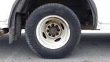 A close-up of a flat tire on a 2011 Ford Econoline showing the wheel rim and tire tread