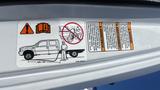 A label displaying warning instructions related to a 2006 Ford LCF 550 with a graphic of a truck and a person operating equipment