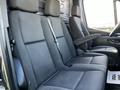 Interior view of a 2021 Mercedes-Benz Sprinter showing the black fabric seats in front of a spacious cabin with headrests and seat belts installed