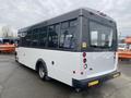 A 2017 Chevrolet Express bus with a white and black exterior featuring large windows and a rear entry door