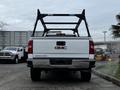 A white 2018 GMC Sierra 1500 pickup truck viewed from the rear with a black truck bed rack attached