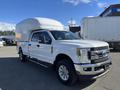 A 2019 Ford F-350 SD truck with a white cargo box on the bed and chrome accents on the front and sides
