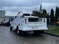 A white 2014 Ford F-350 SD with a utility bed and various mounted equipment at the rear