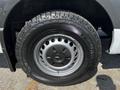 Close-up of a black tire mounted on a 2022 Mercedes-Benz Sprinter featuring a metallic rim with multiple circular holes and a tread pattern designed for all-terrain use