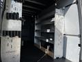 A 2021 Mercedes-Benz Sprinter van interior with metal shelves and storage compartments along the walls