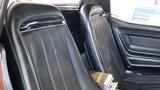 Interior view of a 1971 Chevrolet Corvette Stingray featuring black leather seats with vertical stitching and chrome accents