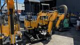 A yellow 2021 Cael-1T Mini with dual arms and a compact design used for trenching and excavation tasks