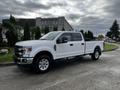 2020 Ford F-250 Super Duty in white with a crew cab and chrome accents parked on a street