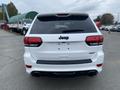 A white 2018 Jeep Grand Cherokee SRT viewed from the rear showcasing its dual exhaust and distinctive Jeep branding on the liftgate