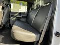 The interior of a 2017 Ford F-150 showing the backseat with a light gray leather bench seat and safety belt visible