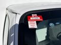 A 2019 Ford Econoline with a red certificate of approval sticker on the window displaying months and expiry details