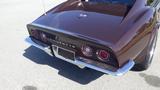 A brown 1971 Chevrolet Corvette Stingray featuring round red taillights and the Corvette emblem on the trunk lid