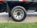 A close-up of a silver wheel on a 2013 Ford F-450 SD with a black tire featuring prominent tread patterns