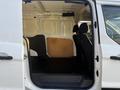 A 2022 Ford Transit Connect with an open side door revealing the interior space featuring two front seats and a spacious cargo area