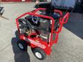 A red 2024 Magnum 4000 Hot Water Pressure Washer on wheels with a large metal tank hoses and controls attached on a sturdy frame