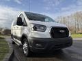 A white 2023 Ford Transit van parked at an angle with a black front grille and alloy wheels