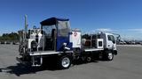 A 2006 Ford LCF 550 truck modified for industrial use featuring a large tank and equipment on the back along with a blue canopy for protection