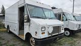 A white 2006 Ford Econoline van with a boxy shape and a diamond-shaped panel on the front, showing signs of wear and tear