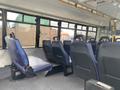 Interior view of a 2018 Chevrolet Express showing blue upholstered seats arranged in rows with a spacious aisle in between