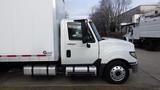 A white 2012 International TerraStar truck with a large cargo box attached on its rear and silver fuel tanks visible on the side