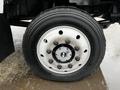 Close-up of a 2005 GMC C5 Duramax front wheel showing a silver rim with multiple bolts and a black tire