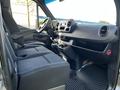Interior of a 2021 Mercedes-Benz Sprinter showcasing the driver and passenger seats dashboard and center console with storage compartments and controls