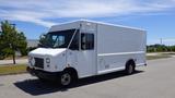 A white 2011 Ford Econoline cargo van with a boxy design and large front windshield parked on a paved surface