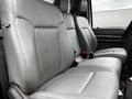 Gray leather upholstery of a 2011 Ford F-250 SD truck's front seats with two seats visible and seatbelts attached