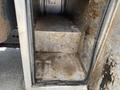 Interior view of a truck compartment with metal steps and a dirty, worn metal floor showing signs of use