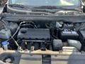 The engine compartment of a 2012 Kia Sportage showing the engine block battery and various components