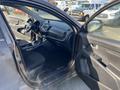 Interior of a 2012 Kia Sportage showing front seats dashboard and controls with an open door to the driver's side