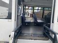 A 2018 Chevrolet Express interior showing two blue seats and a wheelchair lift mechanism at the entrance