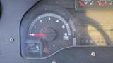 Close-up of a vehicle dashboard gauge displaying RPM with a needle near 2 and oil indicator light illuminated