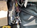 A tangle of wires and cables connected to the interior of a 2010 Ford F-550 with electrical components partially visible