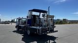 A 2006 Ford LCF 550 service truck equipped with various machinery and a blue canopy on the back