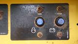 A control panel with two circular blue connectors labeled 50A and 150A along with a battery icon and a light symbol on a metallic surface with visible rust