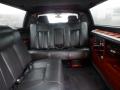 Interior of a 2008 Cadillac Limousine featuring black leather seating and wooden trim