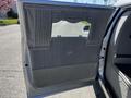 The interior door panel of a 2013 Lincoln MKT featuring soft gray fabric with vertical pleats and a floral design in the center